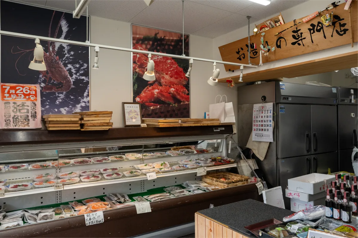 市場の通路で魚を選ぶ店主