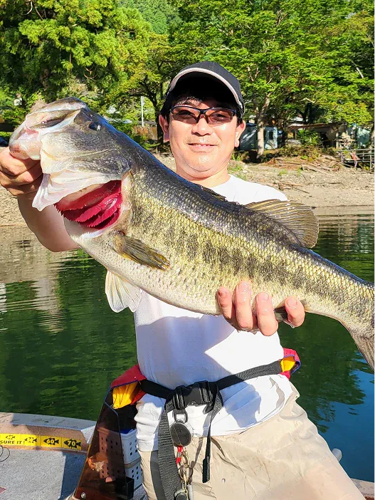 釣り上げた大きな魚を手にする店主