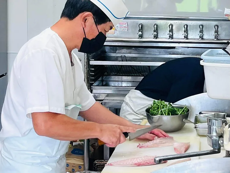 厨房で魚をさばく職人